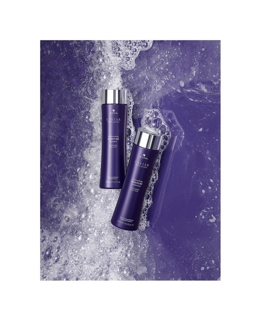 Two purple Caviar shampoo bottles with silver caps are arranged against a textured purple and white bubbling liquid background.