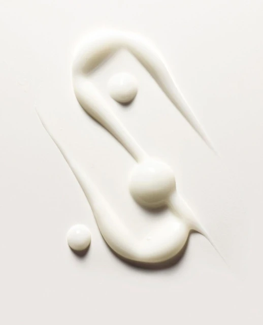 Close-up of swirled skin cream against a white background, showcasing its texture and consistency for beauty and skincare applications.