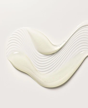 Swirl of pearlescent lotion or cream on white background, ideal for beauty or skincare product demonstration, showing texture.