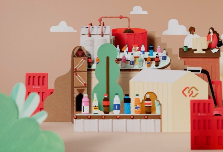 Whimsical paper art scene features a beverage factory, complete with bottles on conveyor belts, employees at computers, and industrial tanks.