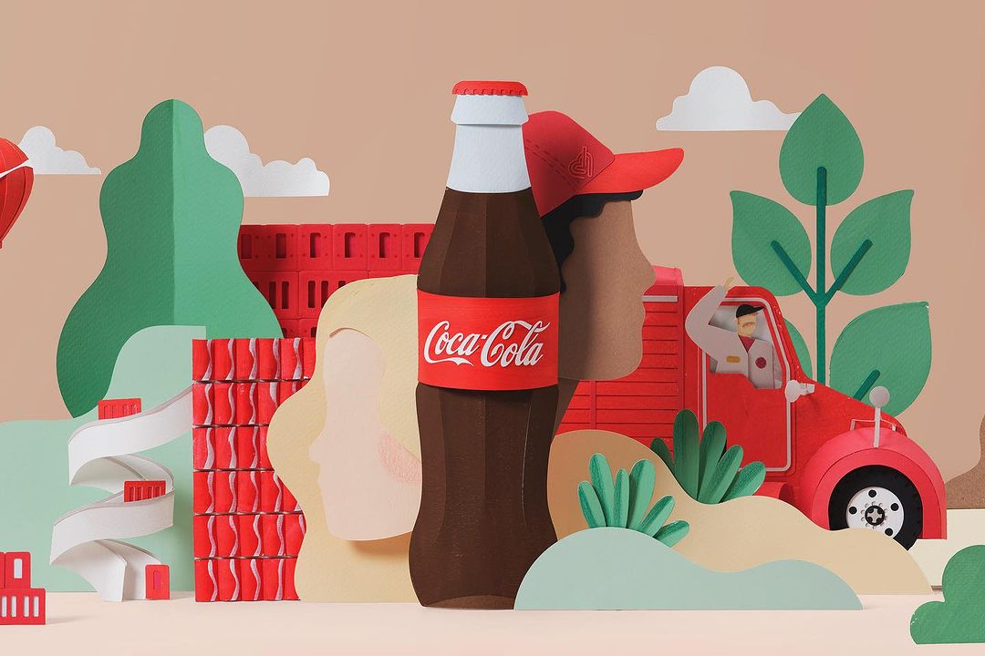 Stylized paper art advertising a Coca-Cola bottle beside a blonde woman and driver in a truck, all set against a tan backdrop.