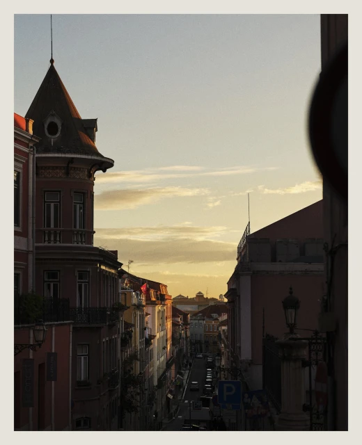 Urban street scene with colorful buildings lining the road under a bright sky, captured during golden hour with natural light.