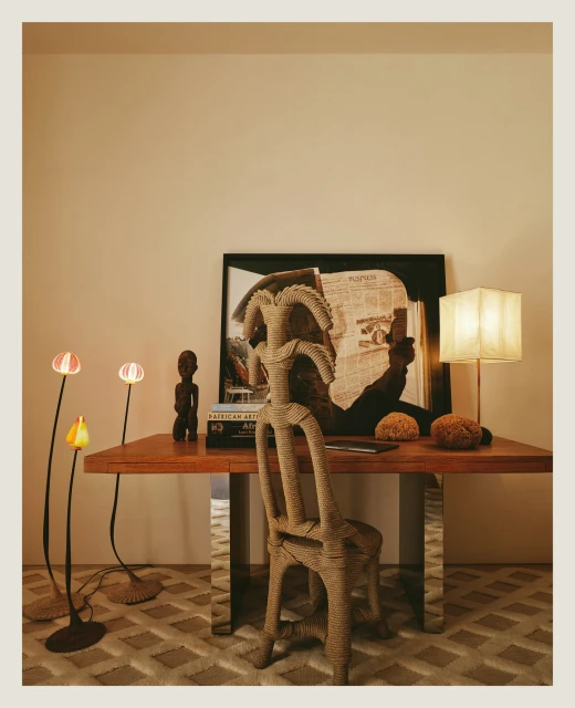 Interior space showcases unique cardboard chair and table setting, complemented by modern floor lamps and a framed art piece backdrop.