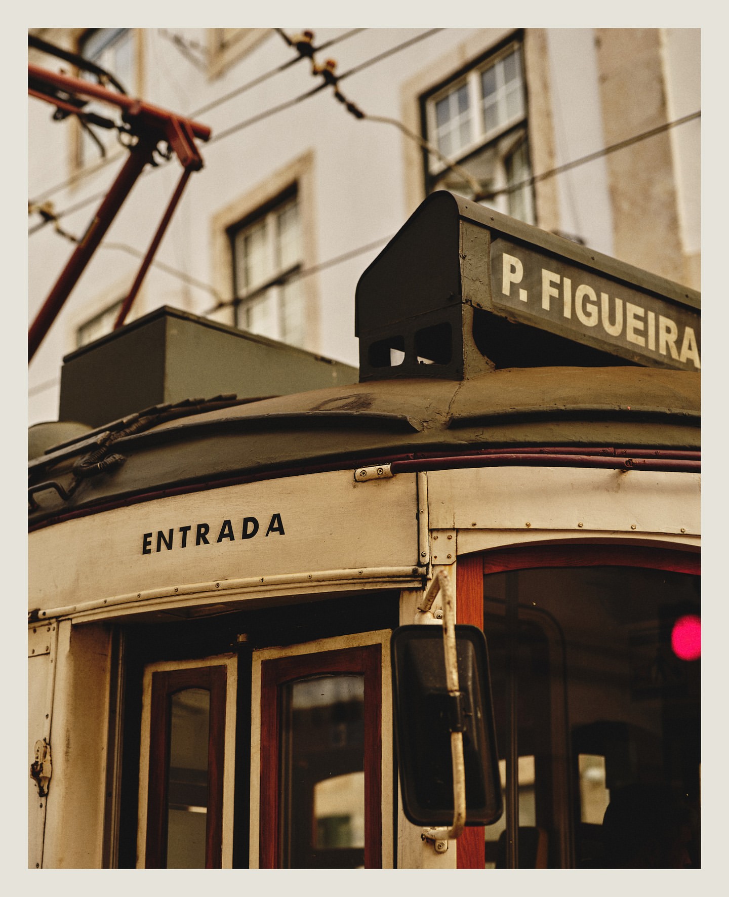 Vintage-style tram with 'Entrada' sign, featuring classic design, aged textures, and urban transport themes, set against a building backdrop.