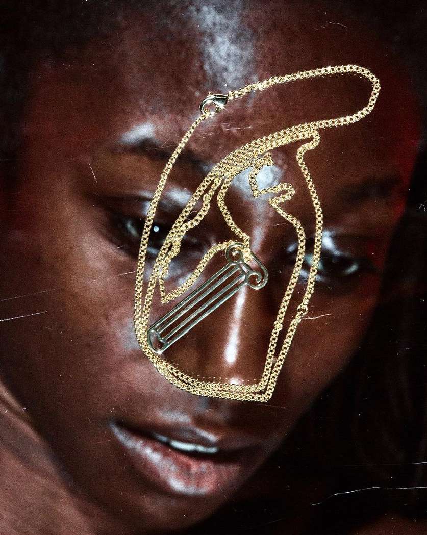 Close-up portrait of a black woman wearing a gold chain necklace photographed by Adrian Samson in London.