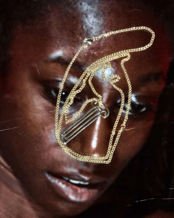 Close-up portrait of a black woman wearing a gold chain necklace photographed by Adrian Samson in London.