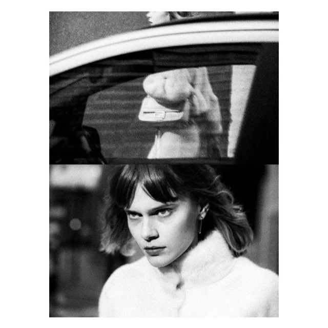 Black and white fashion portrait of a woman in a white fur coat and another woman reflected in a car window in the background.