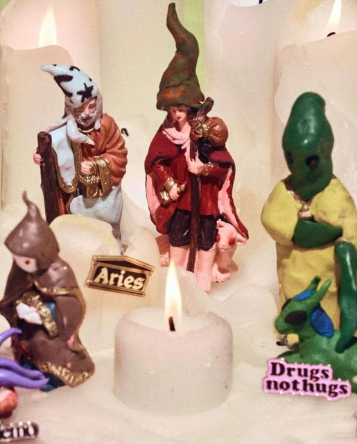A collection of figurine art, featuring candles and small text art, creating an eclectic and unusual visual arrangement.