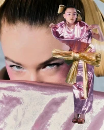 Collage fashion portrait by Adrian Samson featuring a woman in a glossy pink dress with a gold bow against a large cropped face backdrop