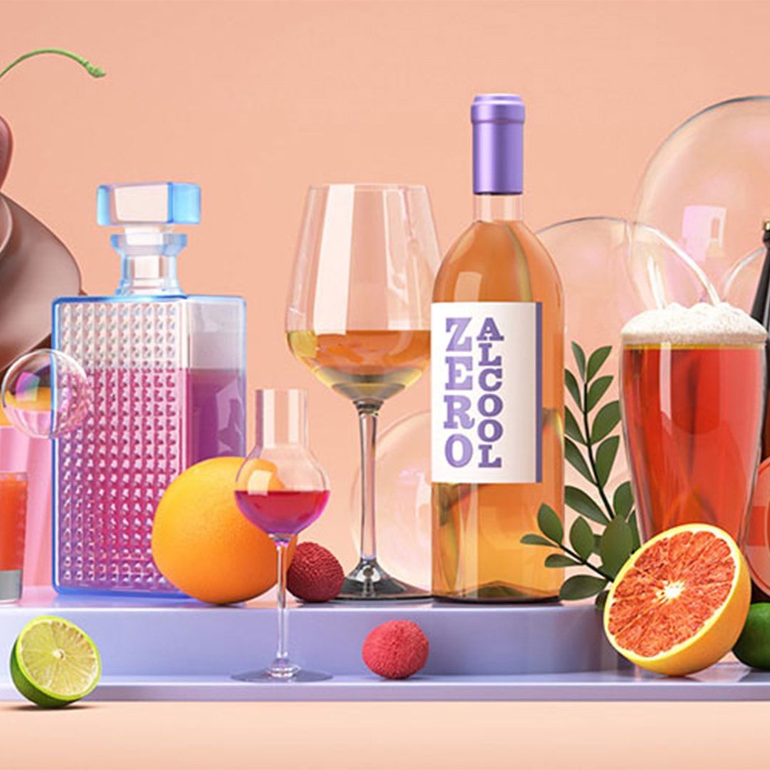 Vibrant still life featuring a bottle of zero alcohol wine, various cocktails, cut citrus fruits, and decorative glass spheres, set against a soft peach backdrop.