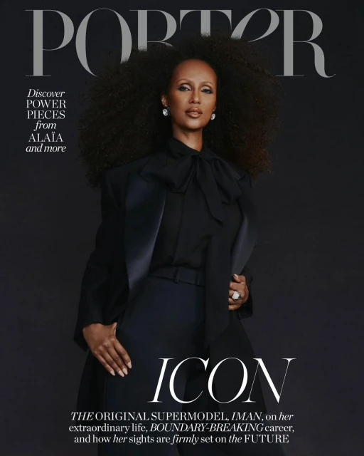 Magazine cover featuring Iman in black suit, large natural hair, diamond earrings and ring, standing against a solid dark backdrop.