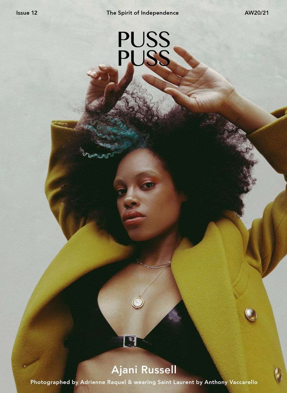 Magazine cover featuring Ajani Russell with afro, wearing a yellow coat and black top, photographed by Adrienne Raquel for Saint Laurent.
