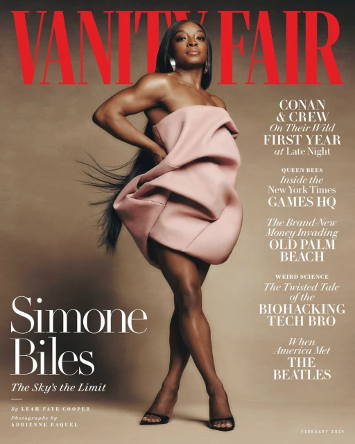 Vanity Fair cover featuring Simone Biles in a pink draped dress, long dark hair, and black heels, set against a neutral backdrop.