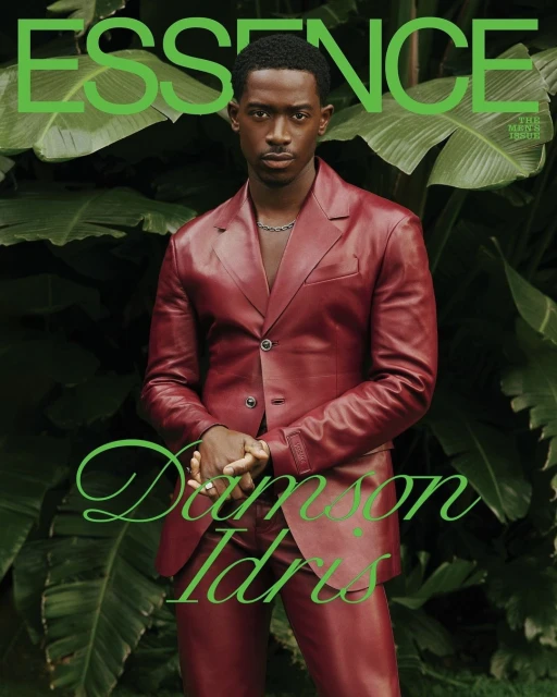 Essence magazine cover featuring Damson Idris in a burgundy suit against a leafy green background, showcasing fashion and celebrity.