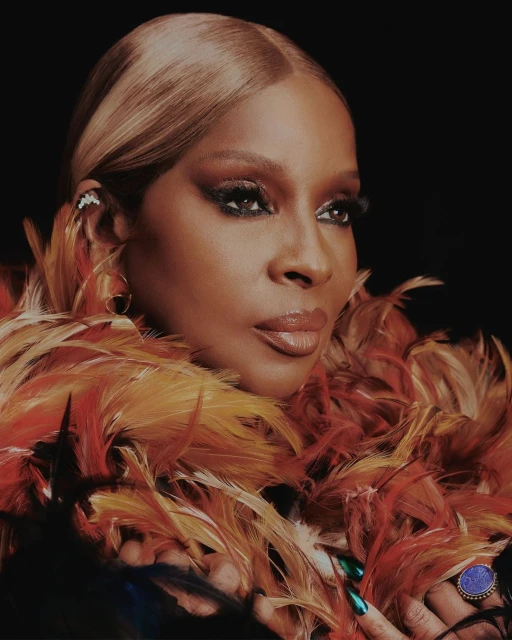 Close-up studio portrait of an adult woman with blonde hair, dramatic eye makeup, and a feather boa. Focus on her face and fashion.