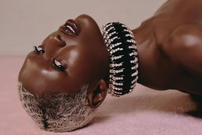 Striking portrait of a Black woman with platinum blonde hair and a jeweled black choker, captured in a close-up studio shot.