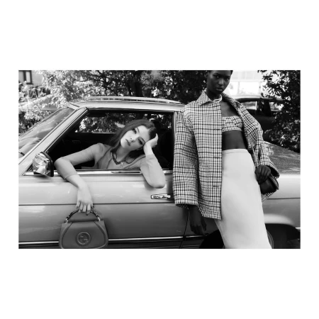 Monochrome fashion editorial featuring two female models posing with a vintage car by Agata Pospieszynska.