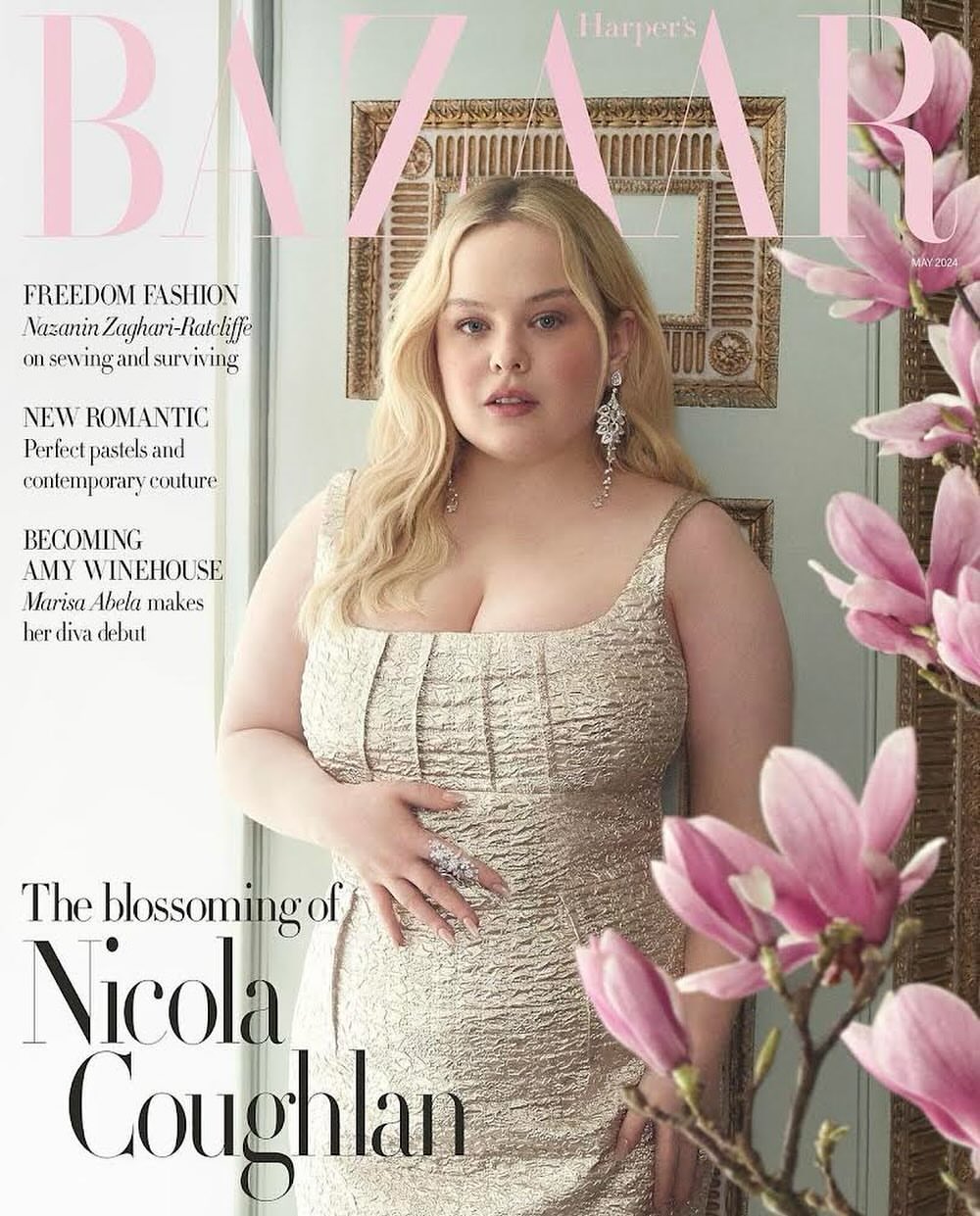 Nicola Coughlan covers Harper's Bazaar, posing in a gold textured dress beside pink magnolia blooms, in a portrait-oriented magazine cover.