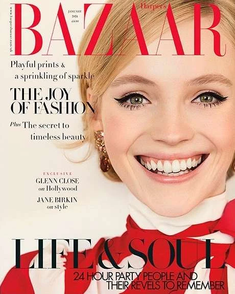 Fashion magazine cover featuring a close-up of a smiling woman with blonde hair, elegant makeup, and a red and white patterned top.