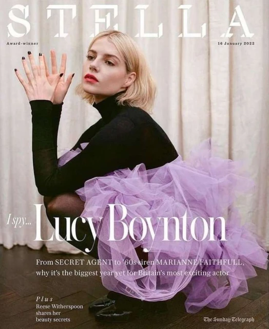 Stella magazine cover featuring Lucy Boynton in a black turtleneck and lavender tulle skirt, kneeling against a neutral background, 14 January 2022.