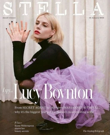 Stella magazine cover featuring Lucy Boynton in a black turtleneck and lavender tulle skirt, kneeling against a neutral background, 14 January 2022.