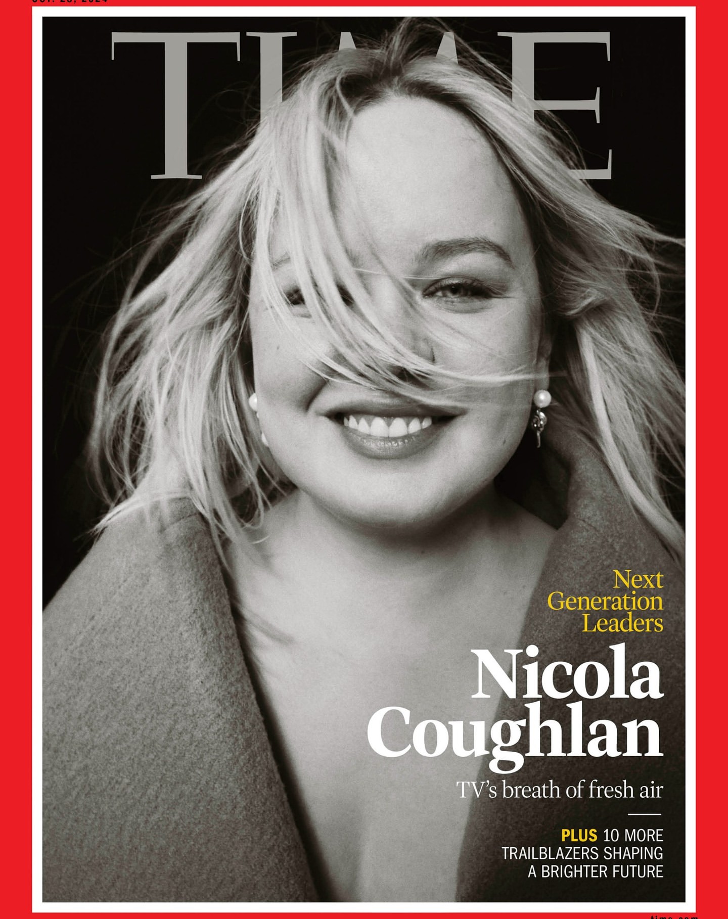 Close-up magazine cover portrait of Nicola Coughlan smiling with blonde hair blowing across her face against a dark background.