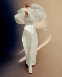 Model in a voluminous white puff-sleeve dress and white shoes posing against a dark gradient studio background.