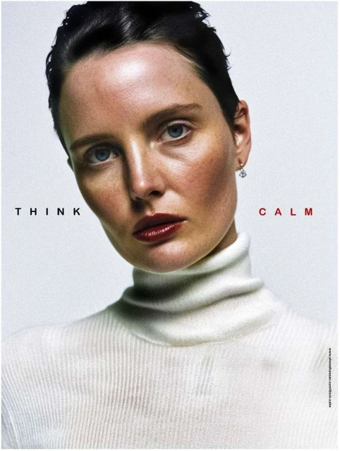 Woman with red lipstick and white turtleneck against a pale backdrop with red 'THINK' and 'CALM' text in a beauty or fashion context.