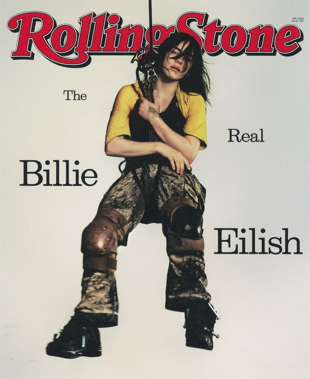 Rolling Stone cover featuring Billie Eilish in knee pads and yellow shirt, holding equipment against a white backdrop with magazine text.