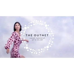 Model in a patterned pink wrap dress walking against a soft cloud-like background with white circular graphics