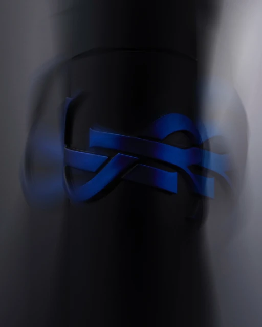 Abstract macro photography of a curved, geometric blue logo on a dark grey background, soft focus, and shallow depth of field.
