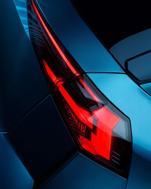 Close-up of a blue car's modern tail light with red LED accents, showing sleek automotive design details and the car's rear panel.
