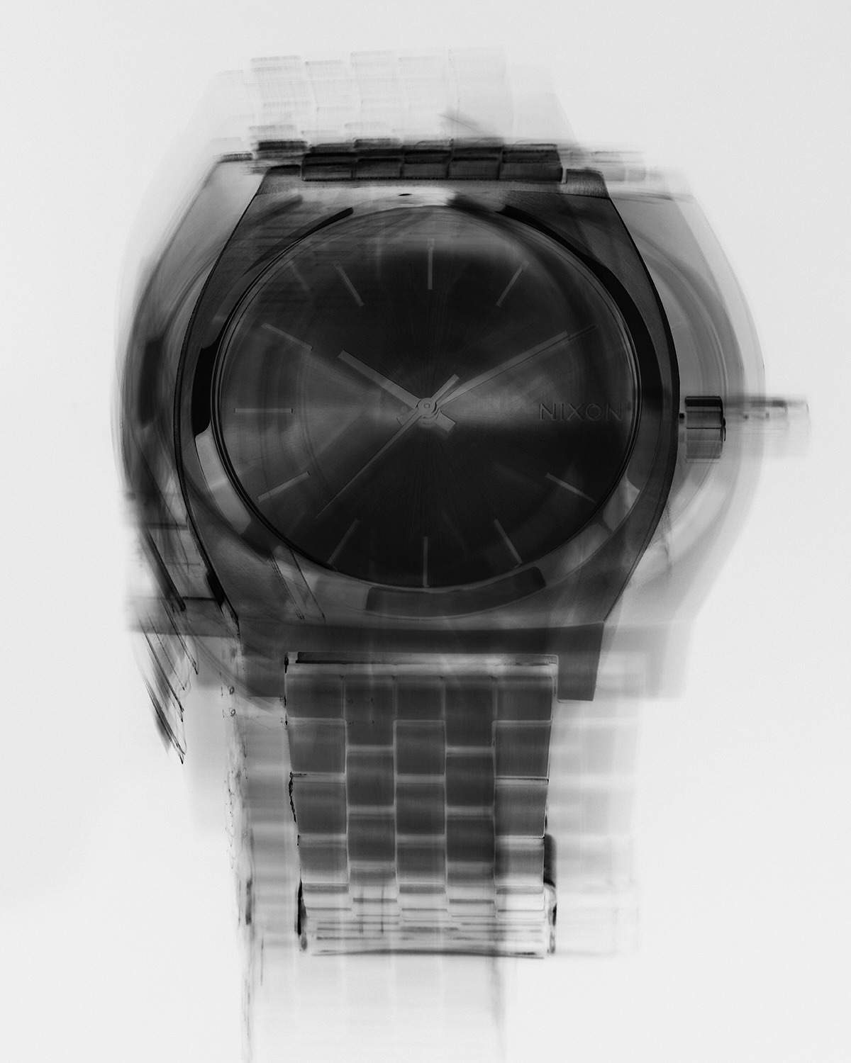 Black and silver wristwatch with blurred effect showing time passing, product shot on a white background with metallic textures.
