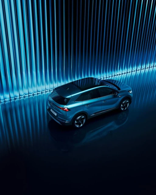 Sleek blue SUV parked indoors with striking blue lighting and a modern design, showcasing automotive style and innovation.