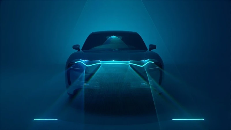 Front view of a sleek automotive vehicle bathed in a cool blue ambiance with striking LED lights, showcasing modern car design.