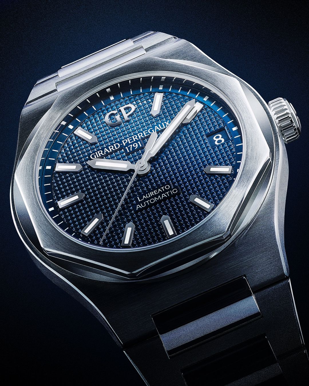 Close-up of a stainless steel Girard-Perregaux Laureato automatic watch with a blue patterned dial and silver hands and hour markers.
