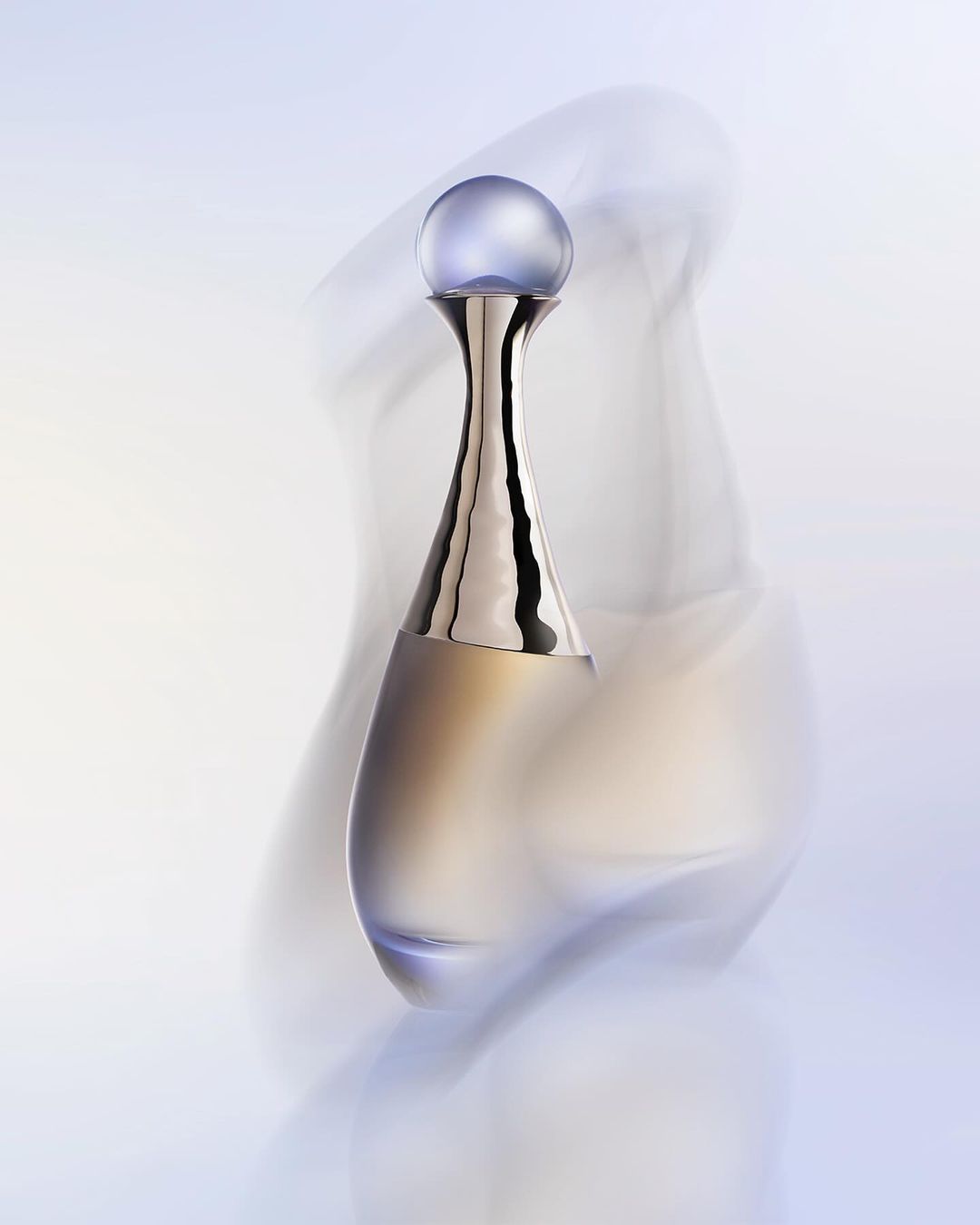 Amphora-shaped perfume bottle with a metallic neck and round purple cap wrapped in swirling translucent fabric in soft light.
