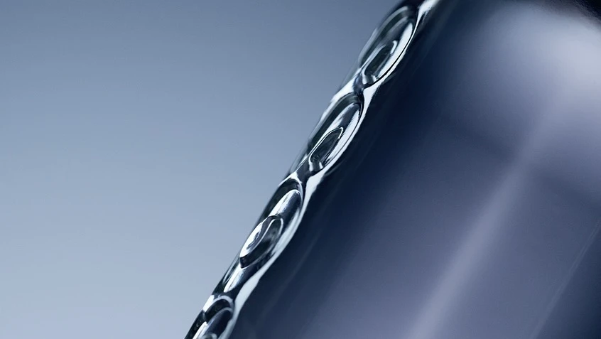 Close-up studio shot of a sleek, metallic container with curved edges, smooth surface, and cool, gradated blue background.