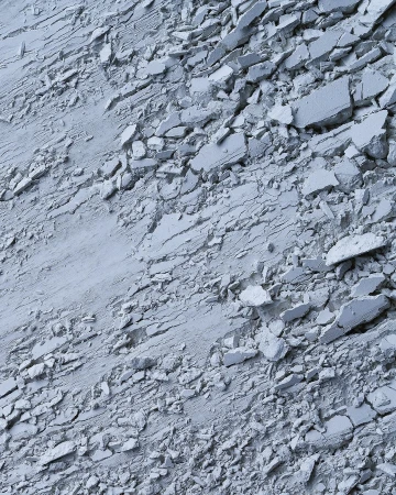 Abstract close-up of fragmented material shows a textured surface with cracks and scattered pieces, offering a monochromatic look.