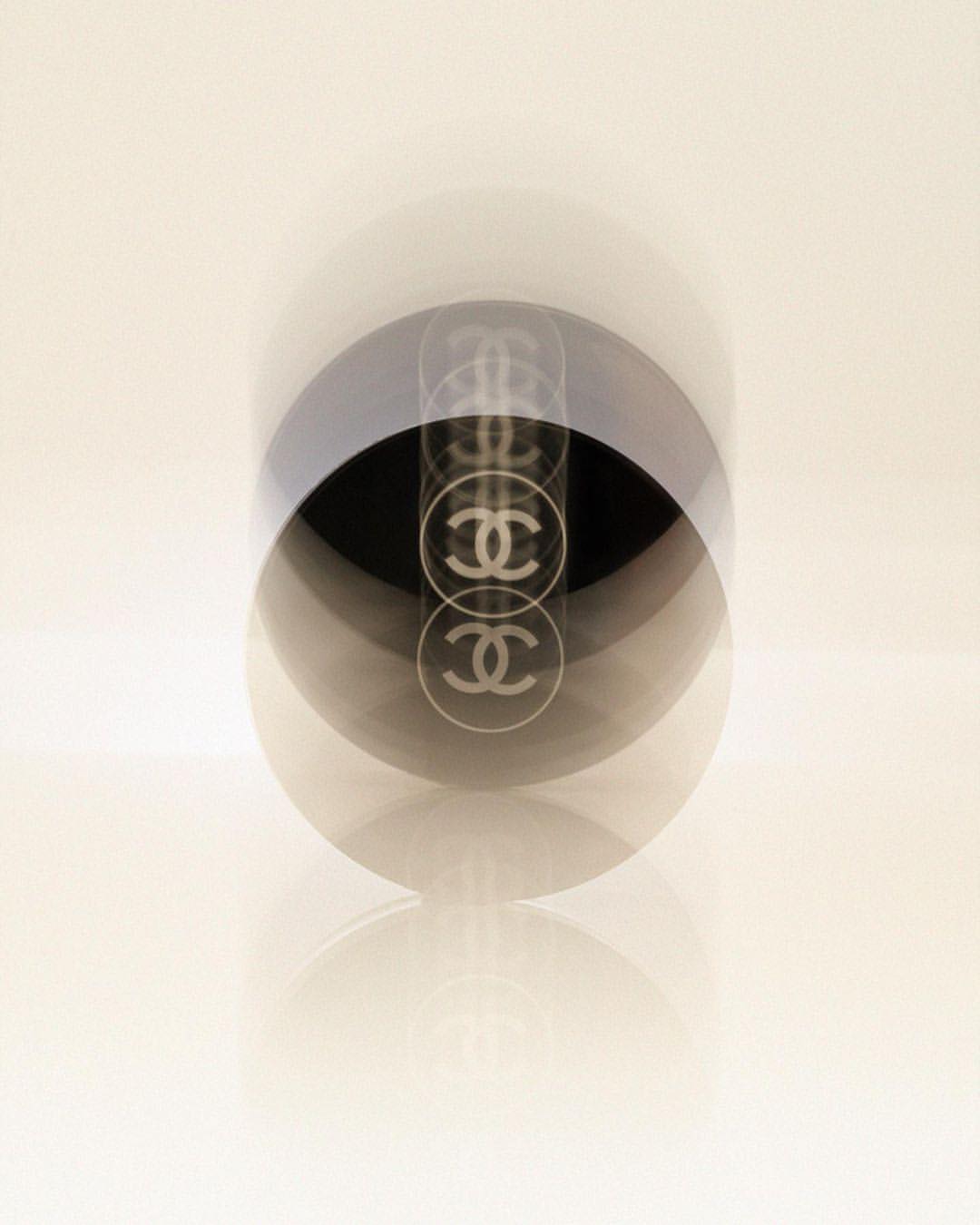 High-key studio shot of a Chanel No. 5 perfume bottle with multiple exposures against a graduated white background. Fashion, Beauty.