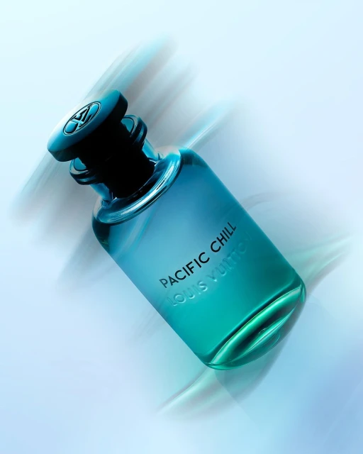 Turquoise-gradient perfume bottle, Pacific Chill by Louis Vuitton, angled view with blurred white background. Beauty, luxury, fragrance product shot.