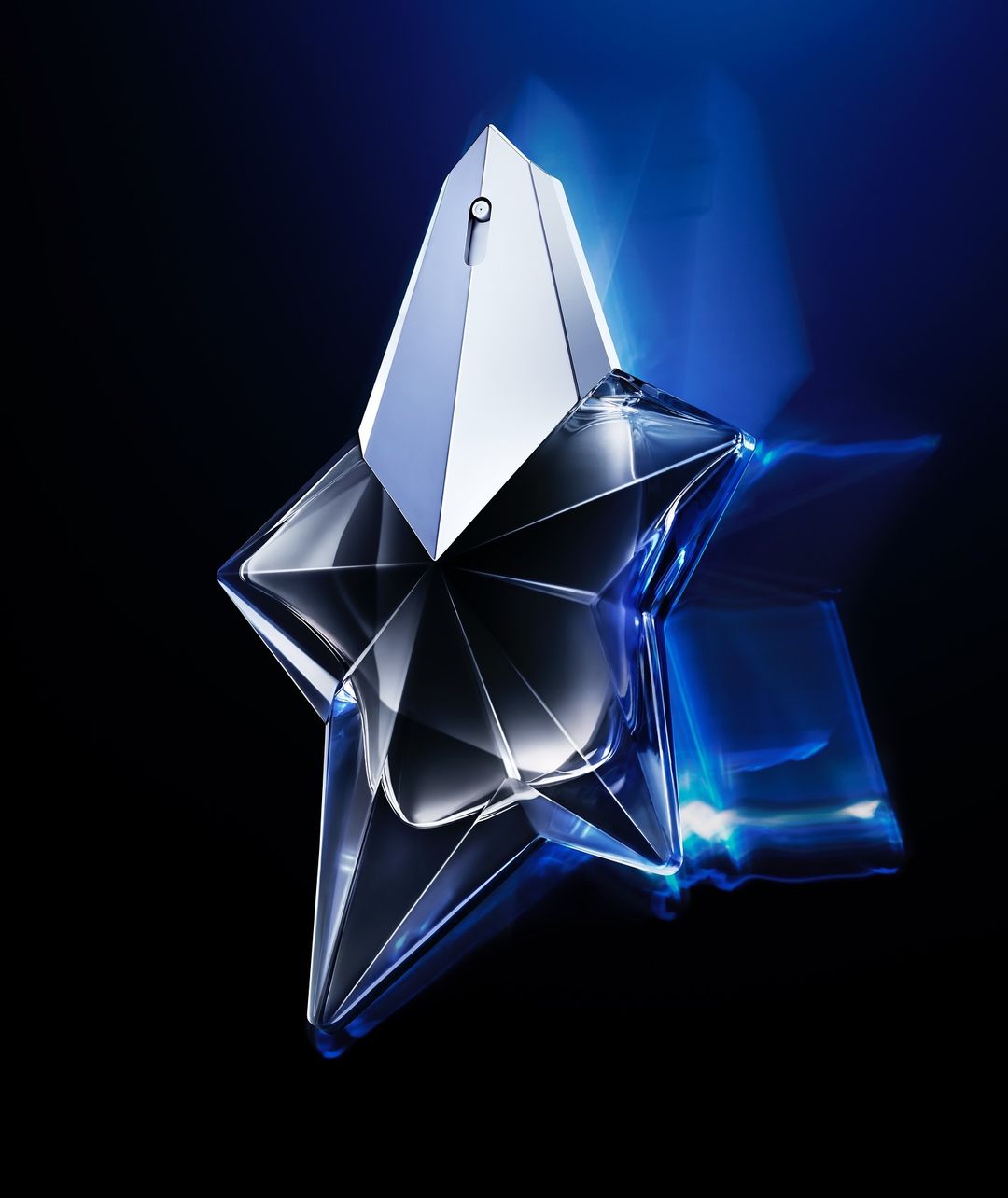 Star-shaped perfume bottle on a black surface with blue light reflecting. Commercial shot with cool tones for a luxury fragrance ad.