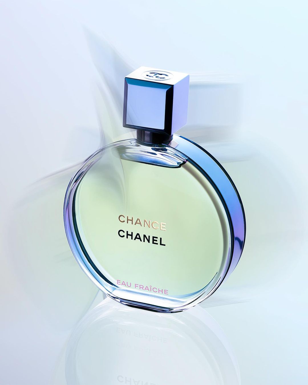Close-up of a round bottle of Chanel Chance Eau Fraiche perfume with a square top, displayed against a soft gradient background.