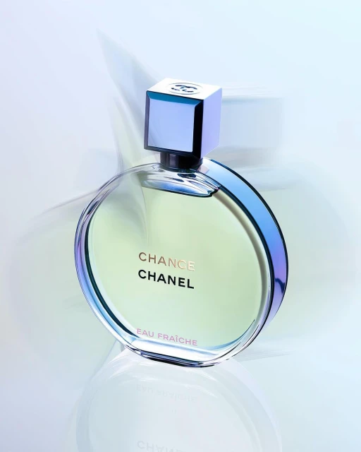 Close-up of a round bottle of Chanel Chance Eau Fraiche perfume with a square top, displayed against a soft gradient background.