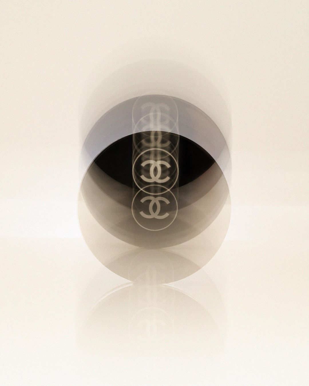 Abstract image of a Chanel perfume bottle with multiple exposures against a light background, creating a motion blur effect.