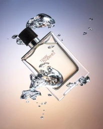 Terre d'Hermes perfume bottle surrounded by floating water droplets against a gradient background shot by Akatre