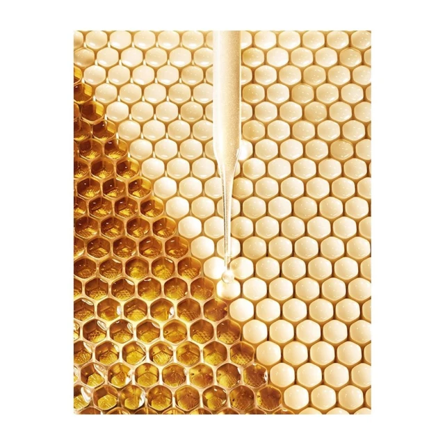 Close-up product shot: golden serum dripping from pipette onto light yellow honeycomb background. Beauty and wellness product photography.
