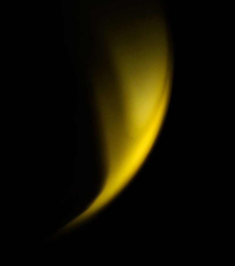 Abstract photography featuring a vibrant yellow light streak set against a stark black background, creating a dynamic visual contrast.