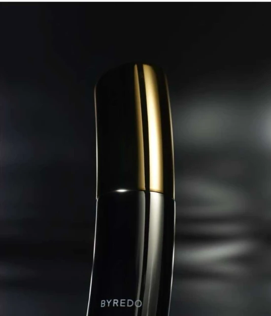Close-up of a black Byredo perfume bottle with a gold cap against a blurred, dark background. Elegant presentation for beauty product.