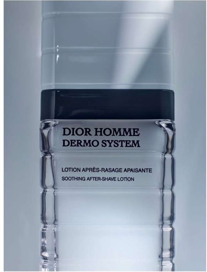 Product shot of Dior Homme Dermo System lotion bottle, featuring sleek packaging and monochromatic color scheme against soft lighting.